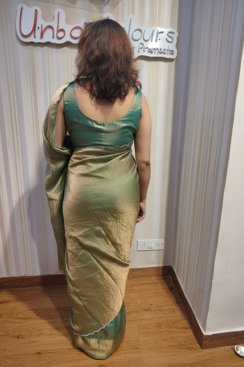 Embrace effortless elegance with Sage Green Shimmer, a graceful Soft Space Silk ready-to-wear saree from Aura Drapes by Unbox Colours, designed for style, comfort & modern sophistication. Featuring a soothing sage green shimmer with a soft, luxurious drape, this pre-stitched saree is perfect for festive celebrations, wedding functions, cocktail parties, receptions, day events & elegant family gatherings. Lightweight, stylish & easy to wear—drape it in minutes & shine with understated glamour.