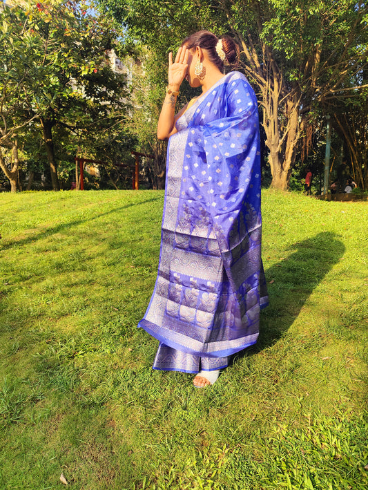 Grace every celebration with this Blue Ready-to-Wear Saree from Aura Drapes by Unbox Colours. This stunning Saree is crafted for effortless elegance & comfort. Featuring a rich Beautiful Blue shade with intricate woven detailing of Silver & Gold Zari. This pre-stitched saree is perfect for weddings, festive occasions, receptions, sangeet nights, family functions & party wear. Easy to drape & beautifully traditional, it’s designed to make you shine with confidence at every special moment.
