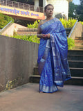 Grace every celebration with this Blue Ready-to-Wear Saree from Aura Drapes by Unbox Colours. This stunning Saree is crafted for effortless elegance & comfort. Featuring a rich Beautiful Blue shade with intricate woven detailing of Silver & Gold Zari. This pre-stitched saree is perfect for weddings, festive occasions, receptions, sangeet nights, family functions & party wear. Easy to drape &amp; beautifully traditional, it’s designed to make you shine with confidence at every special moment.