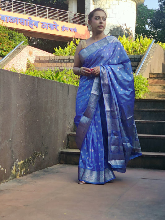 Grace every celebration with this Blue Ready-to-Wear Saree from Aura Drapes by Unbox Colours. This stunning Saree is crafted for effortless elegance & comfort. Featuring a rich Beautiful Blue shade with intricate woven detailing of Silver & Gold Zari. This pre-stitched saree is perfect for weddings, festive occasions, receptions, sangeet nights, family functions & party wear. Easy to drape &amp; beautifully traditional, it’s designed to make you shine with confidence at every special moment.
