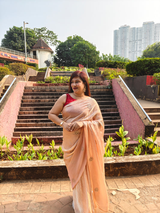 Elevate your festive & party look with this Champagne Gold Ready to Wear Saree from Aura Drapes by Unbox Colours. Designed for effortless draping, this pre-stitched saree combines timeless grace with modern comfort. Crafted in lightweight flowy fabric with delicate embellishments, it's perfect for festivals, weddings, parties & special occasions. Style, comfort & sophistication - ready in minutes.

It's peachy tone, combined with a modern, functional design, make it the perfect choice for every occasion.