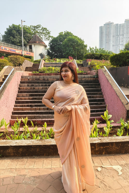 Elevate your festive & party look with this Champagne Gold Ready to Wear Saree from Aura Drapes by Unbox Colours. Designed for effortless draping, this pre-stitched saree combines timeless grace with modern comfort. Crafted in lightweight flowy fabric with delicate embellishments, it's perfect for festivals, weddings, parties & special occasions. Style, comfort & sophistication - ready in minutes.

It's peachy tone, combined with a modern, functional design, make it the perfect choice for every occasion.